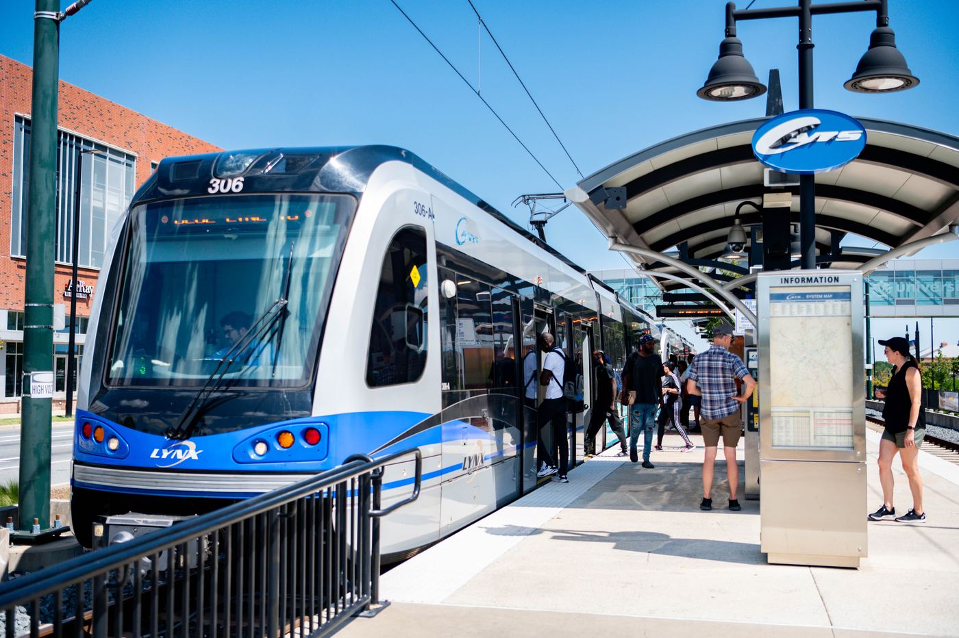 Riders boarding a CATS LYNX light rail train at a station